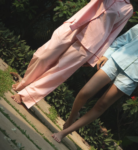 Person wearing a pink outfit standing on a grassy area with plants in the background